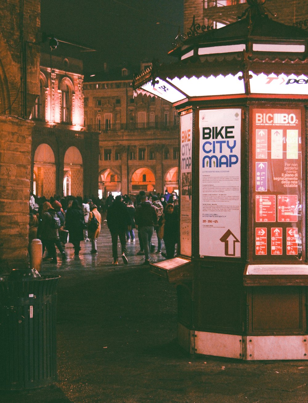 a group of people walking down a street at night