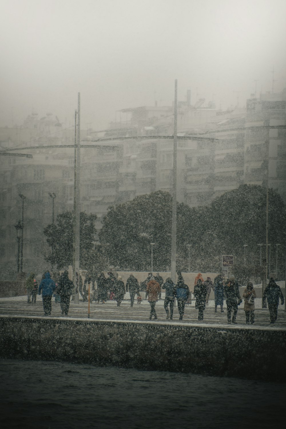 a group of people walking down a street in the rain