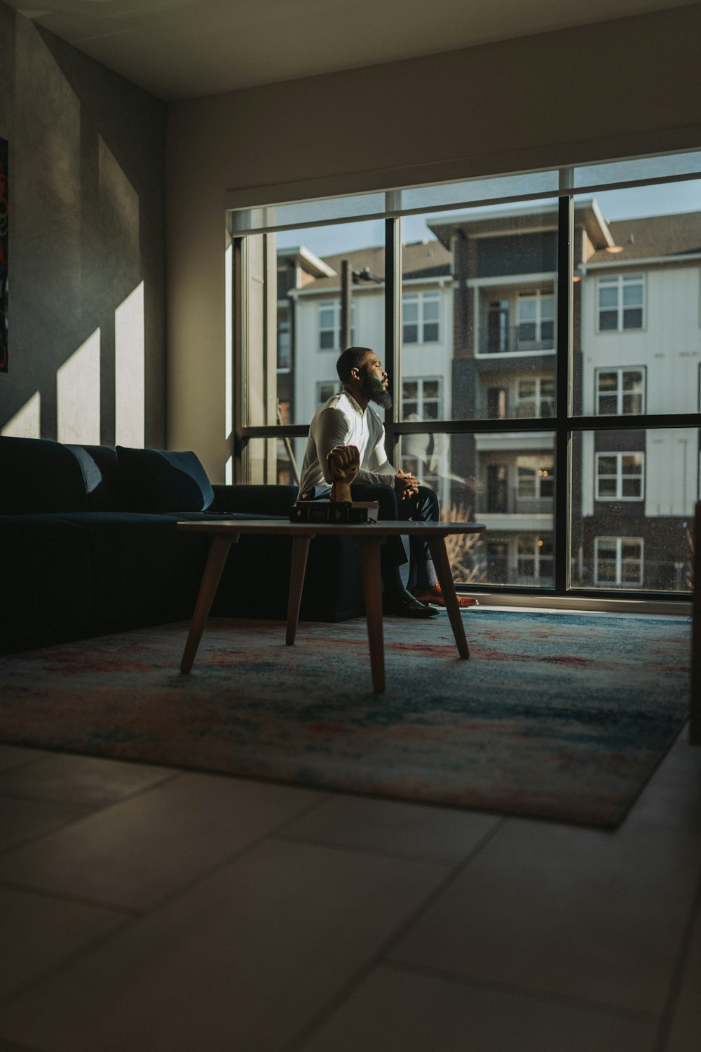 a man sitting on a couch looking out a window