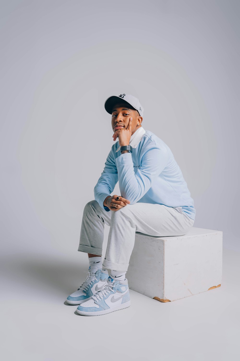 a man sitting on top of a white box