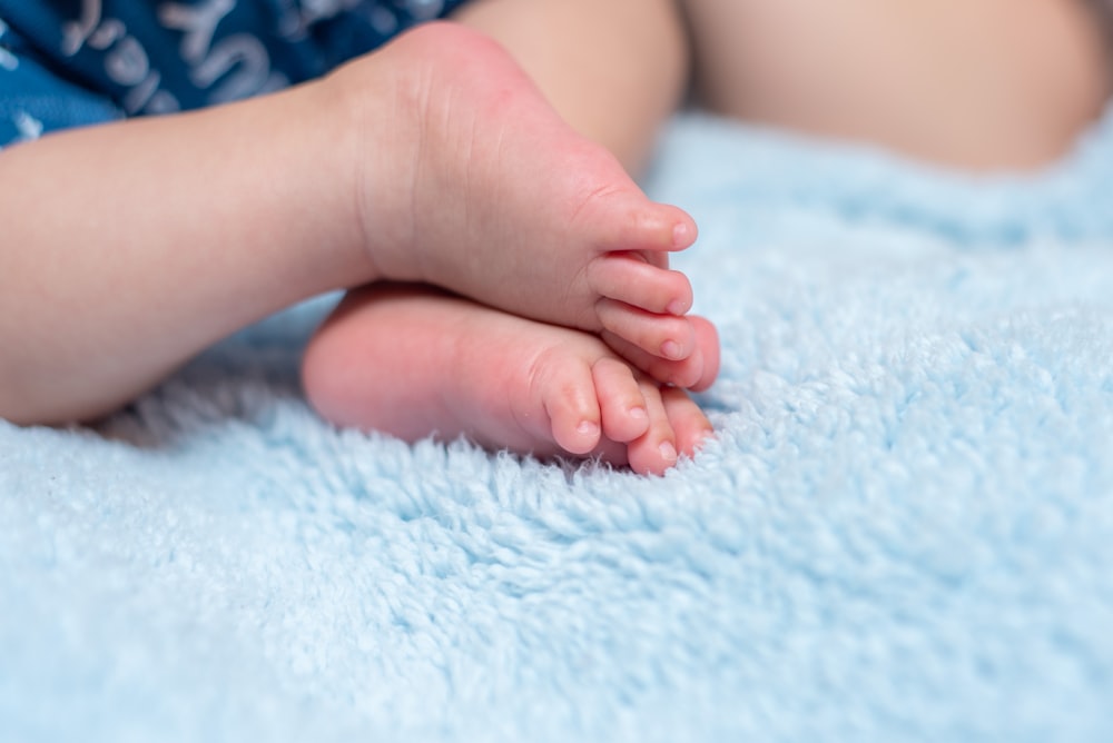 a close up of a baby's foot on a blue blanket