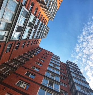 a very tall red brick building next to other tall buildings