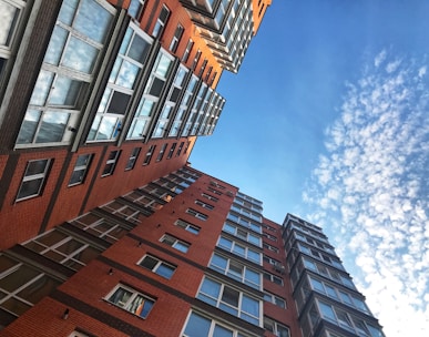 a very tall red brick building next to other tall buildings