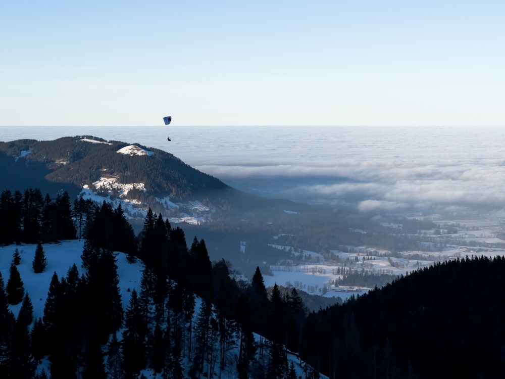 a hot air balloon flying over a snow covered mountain