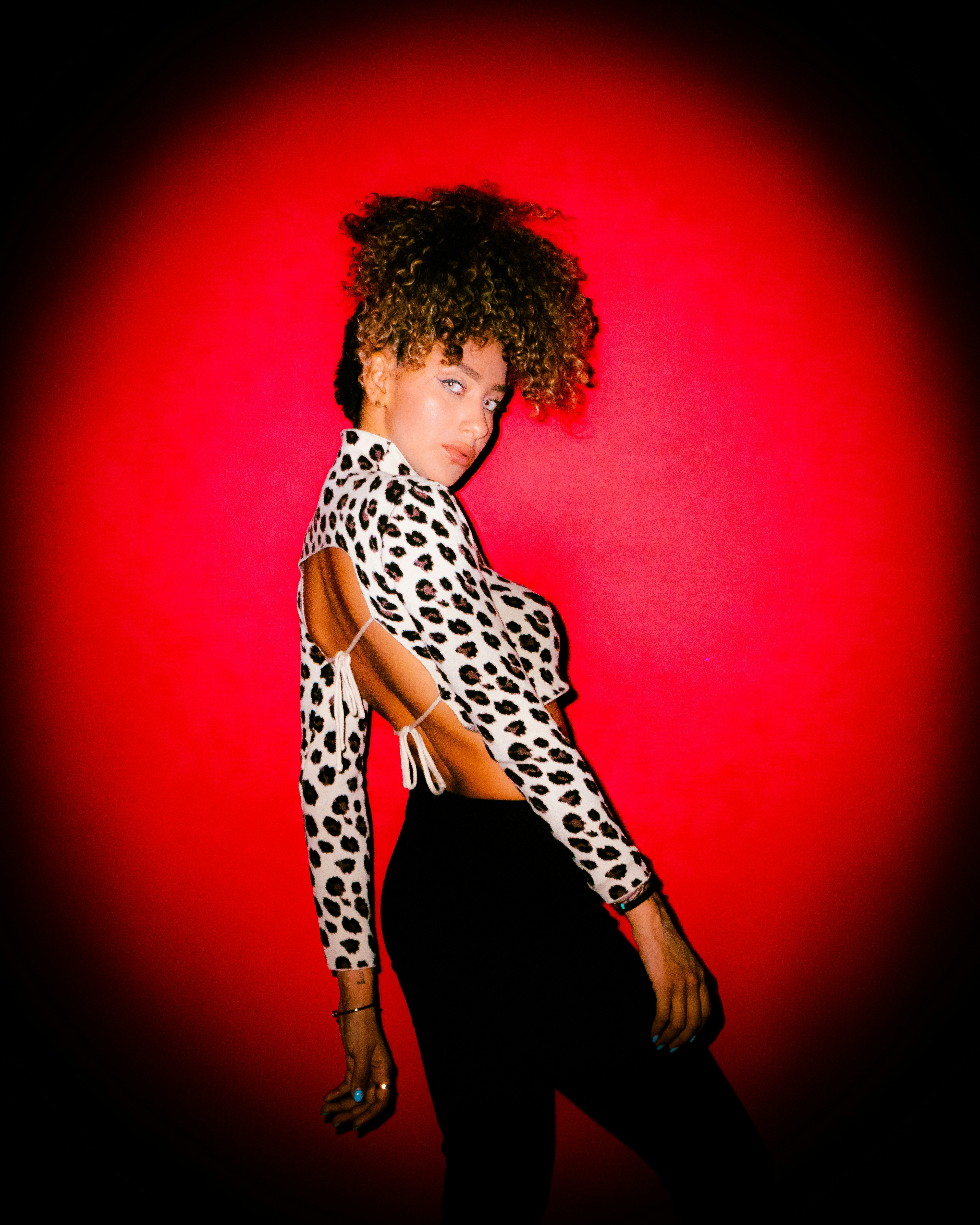 Une femme vêtue d’une chemise imprimée léopard et d’un pantalon noir