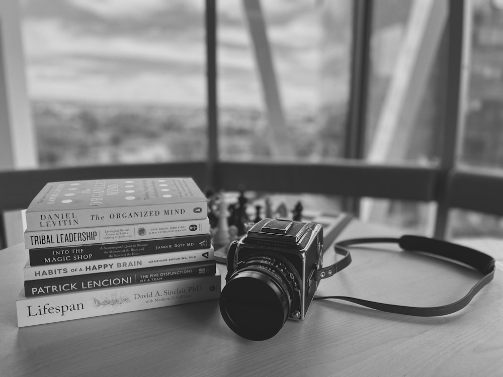 a camera sitting on top of a table next to a stack of books