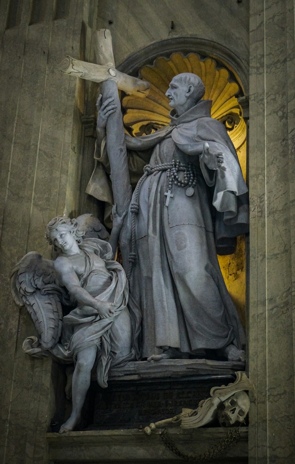 a statue of a man holding a cross next to a woman