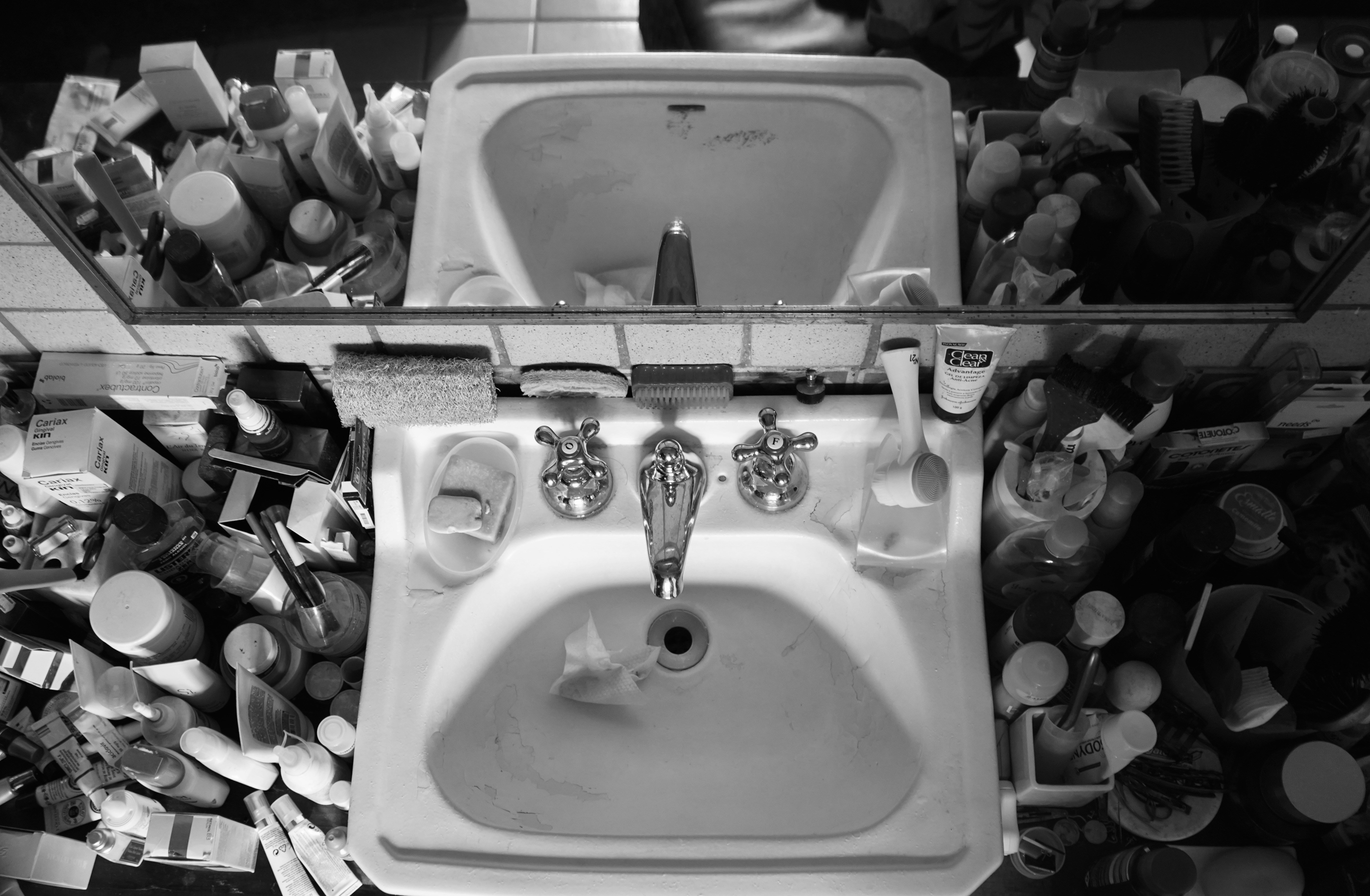 Cluttered bathroom sink with outdated accessories