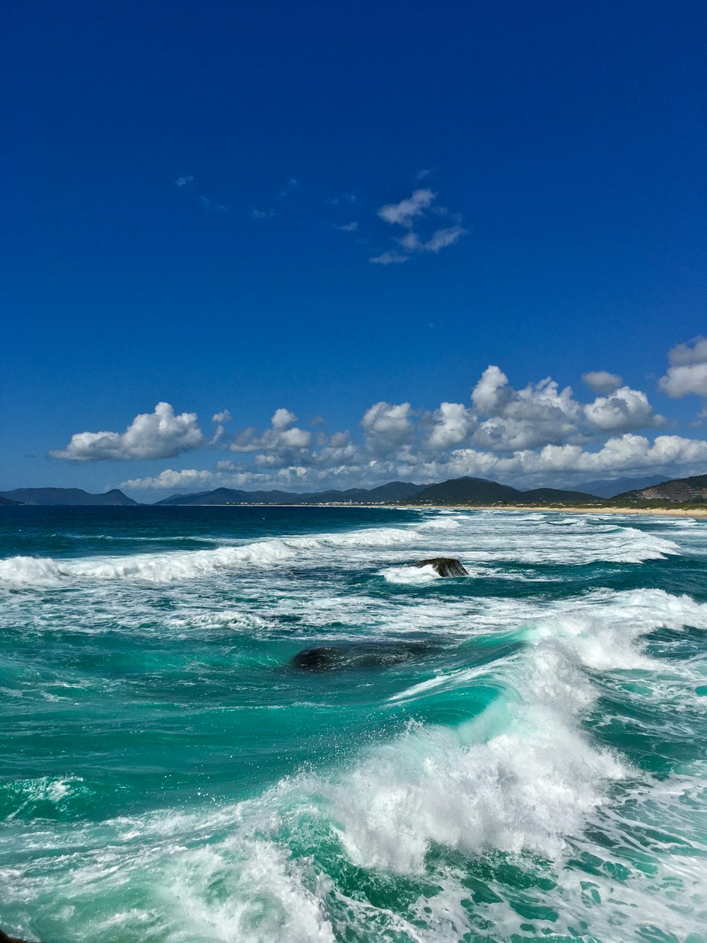 a beach with waves crashing on the shore