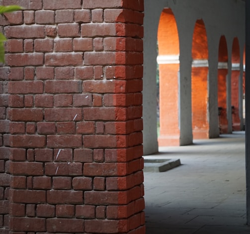 a red brick wall with arches in the background