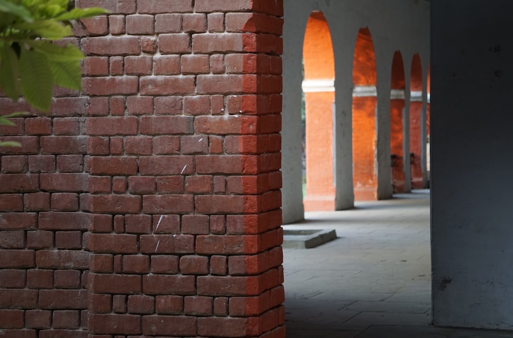 a red brick wall with arches in the background