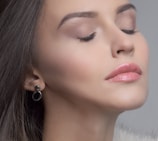 Portrait of a serene woman glowing with fresh, natural makeup in warm tones.