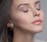 A close-up of a radiant woman showcasing flawless makeup with a soft, elegant background.