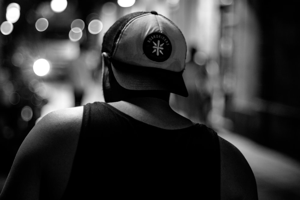 a black and white photo of a person wearing a hat