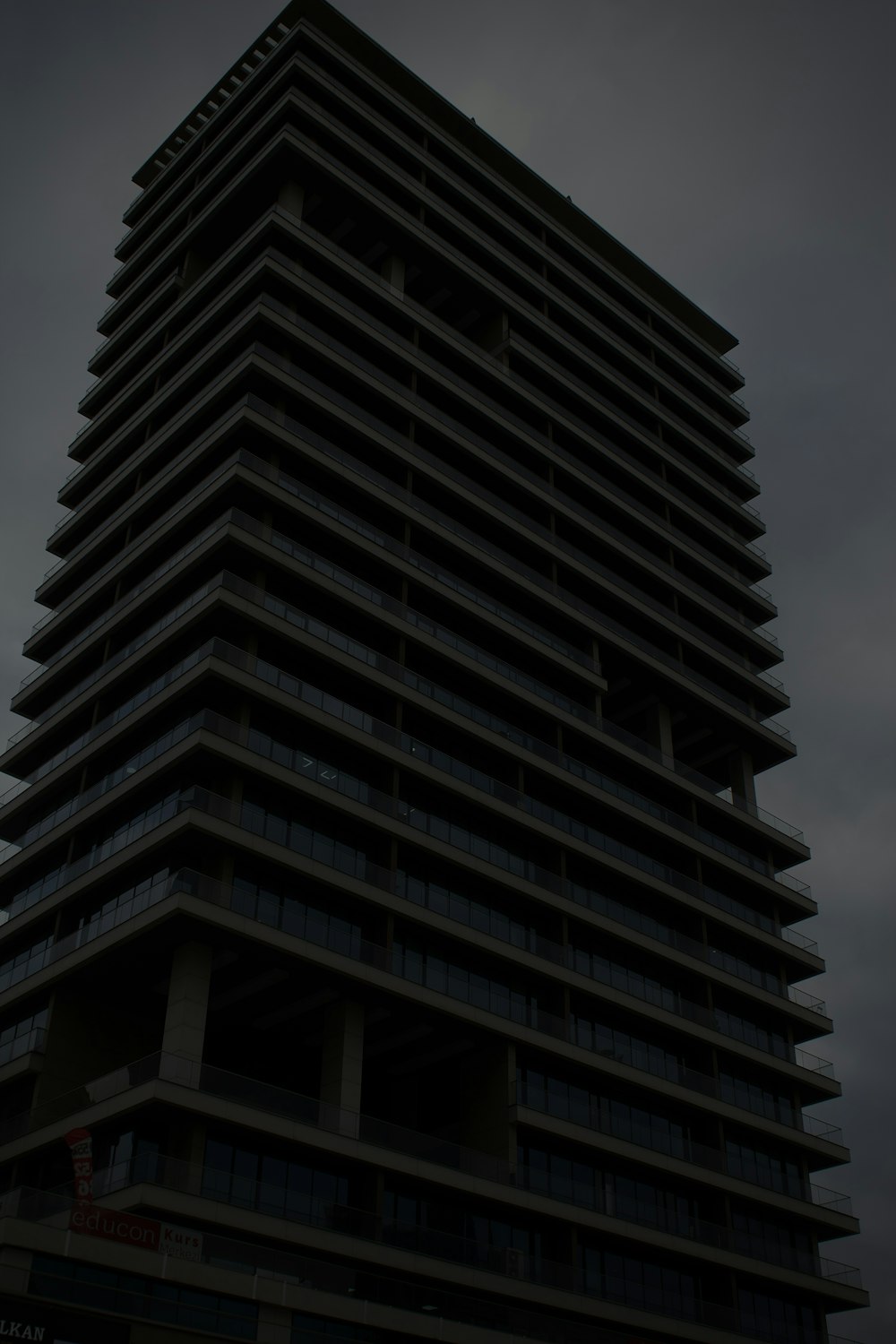 um edifício muito alto com um céu muito escuro ao fundo