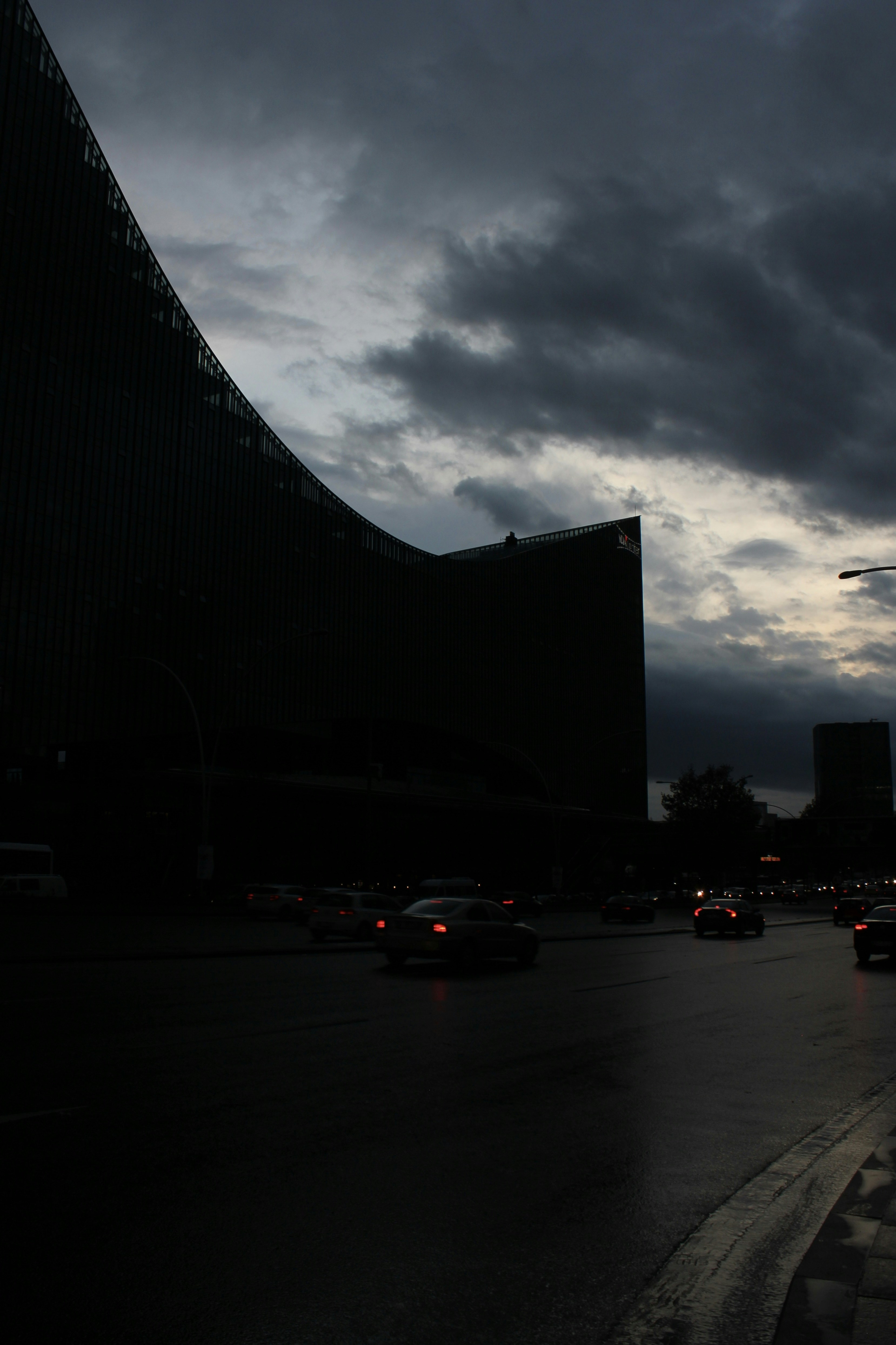 a dark city street with cars driving on it