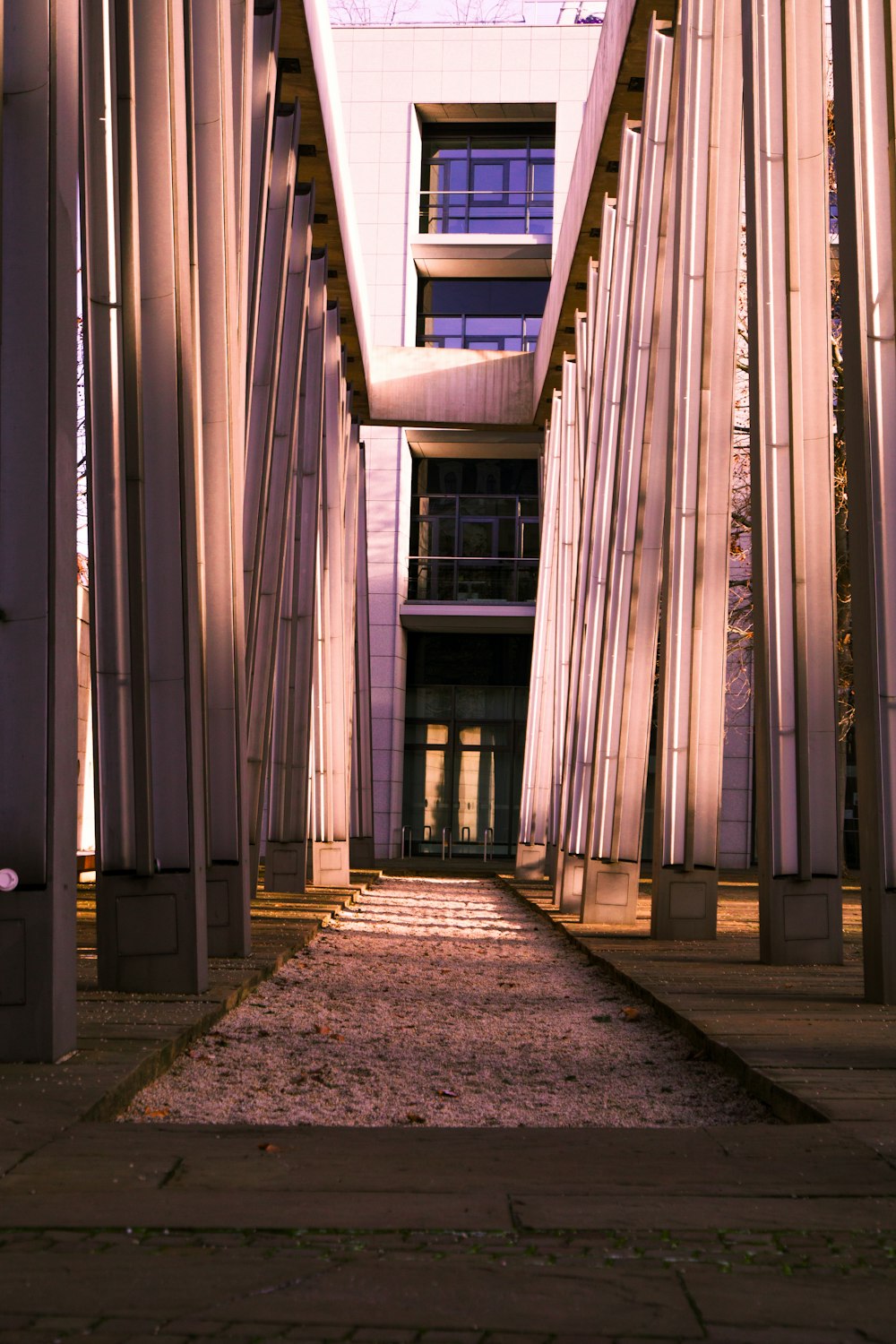 a walkway between two buildings with a clock tower in the background