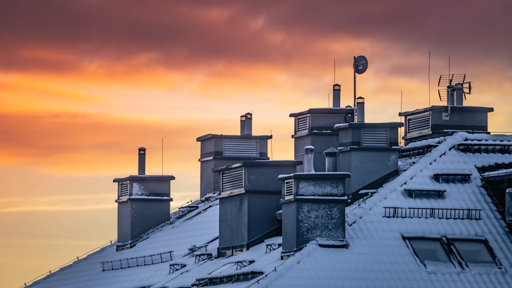 a row of chimneys on top of a building covered in snow