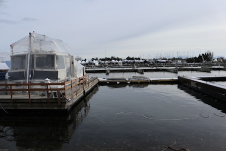 Covered storage units protecting boats during the winter season, surrounded by peaceful greenery.