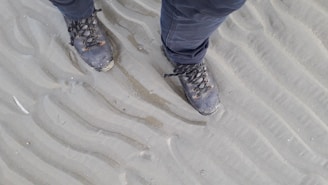 A weathered soldier’s boots resting on desert sands at sunset, symbolizing resilience and memories beyond the ridge.