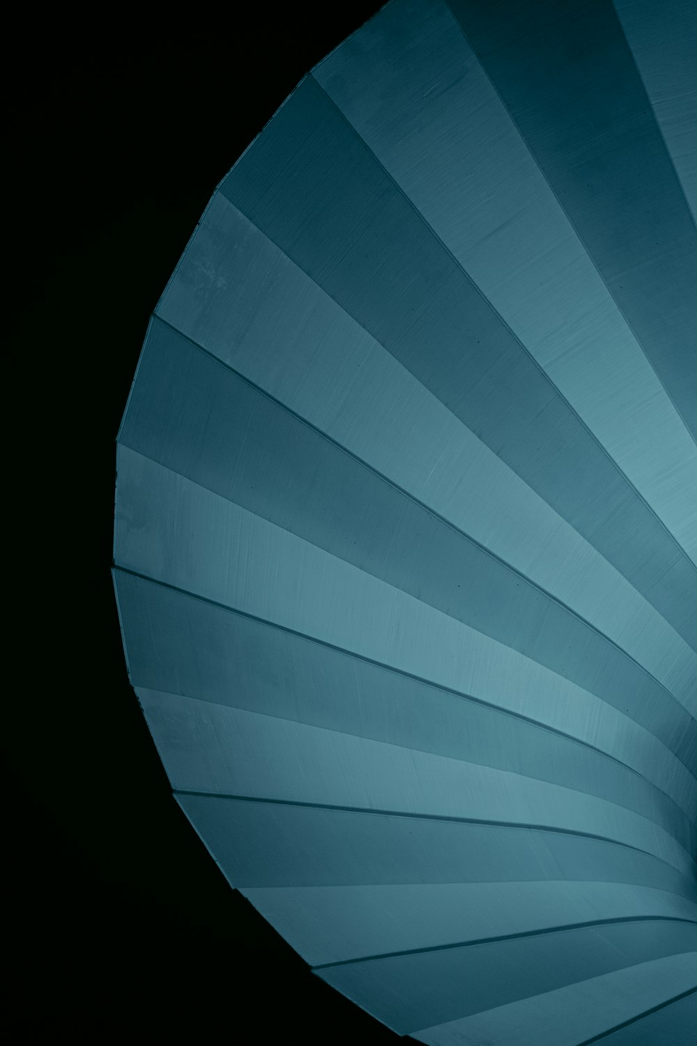 a close up of a blue umbrella with a black background