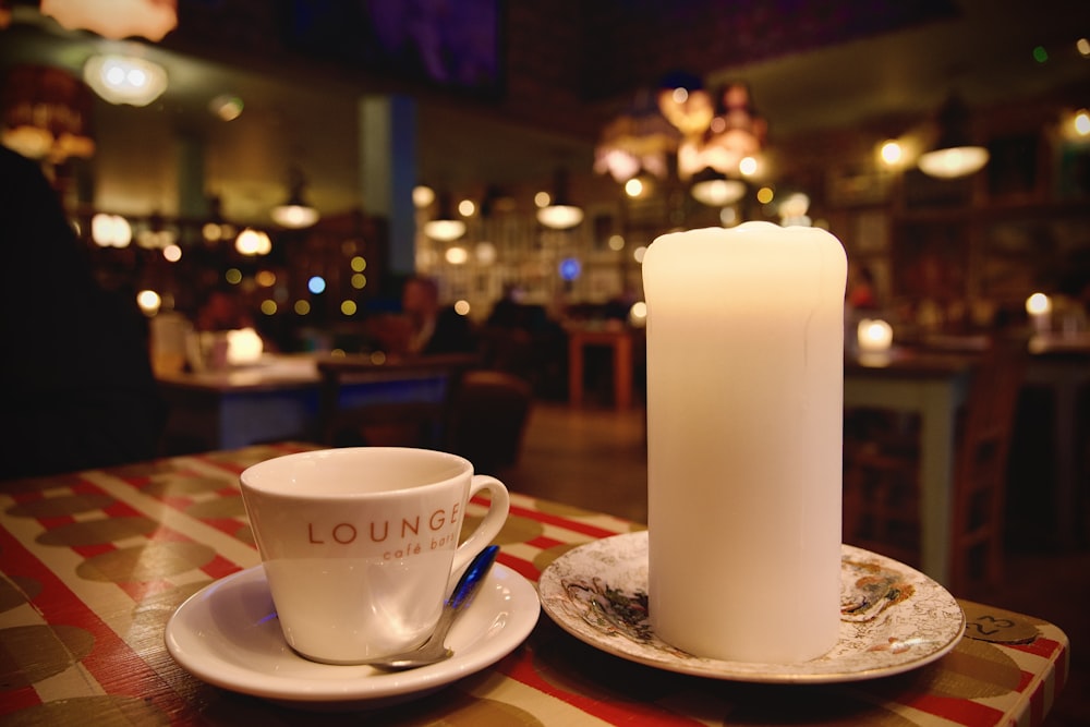 a candle and a cup on a table