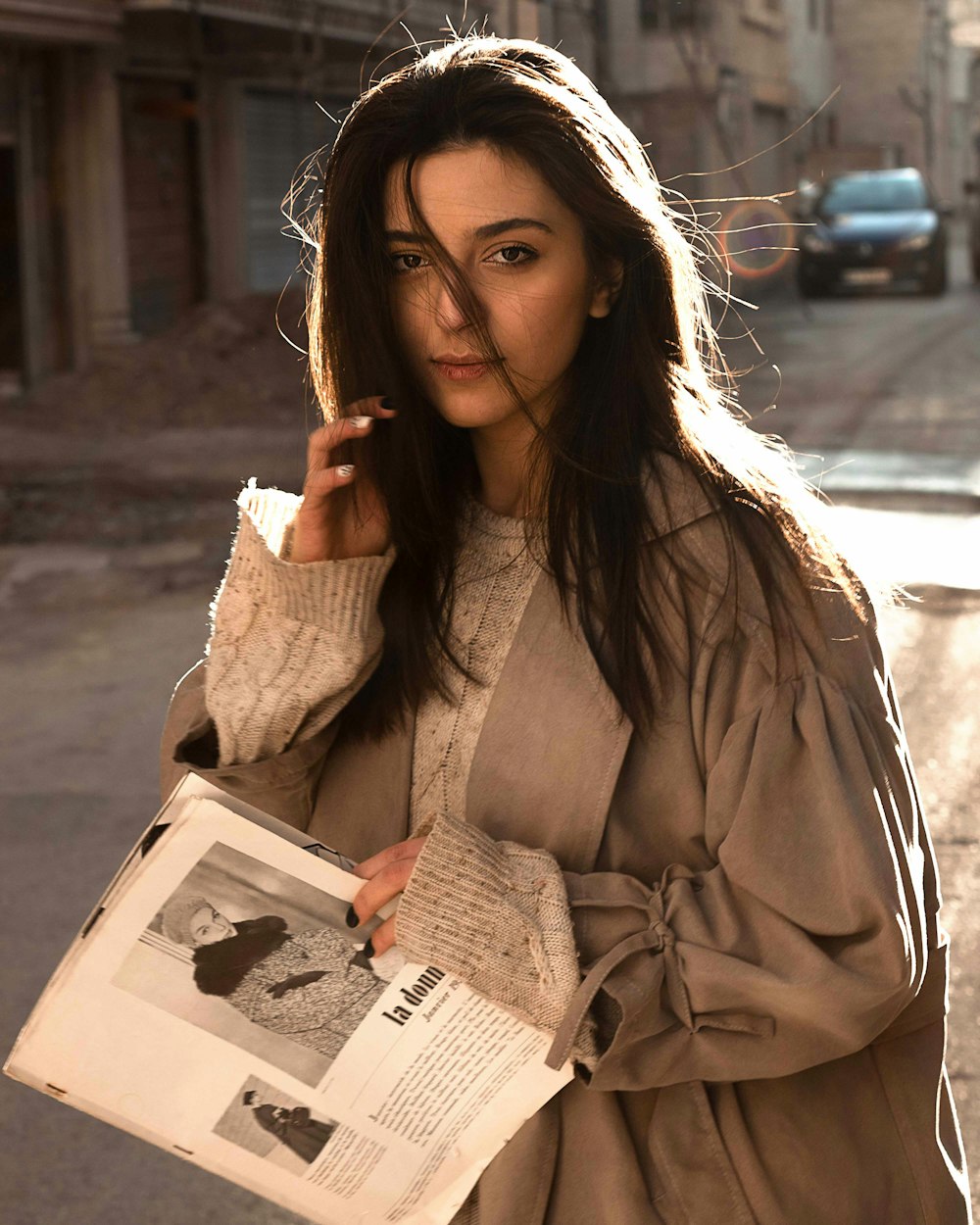 a woman holding a newspaper and smoking a cigarette