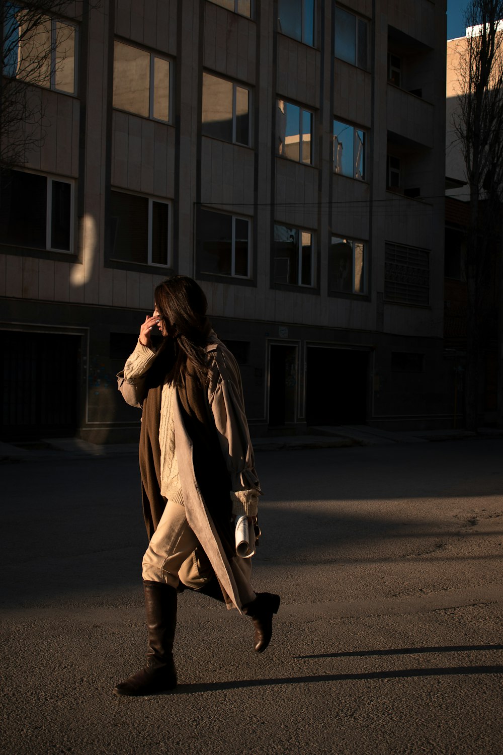 a woman walking down a street while talking on a cell phone