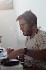 a man sitting at a desk with headphones on