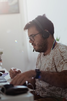 a man sitting at a desk with headphones on