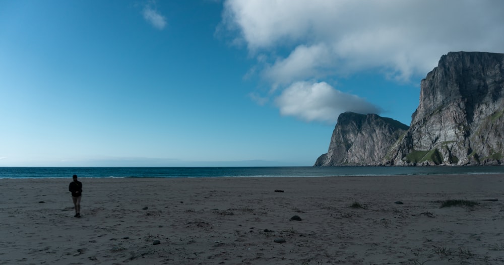 a person standing on a beach near the ocean