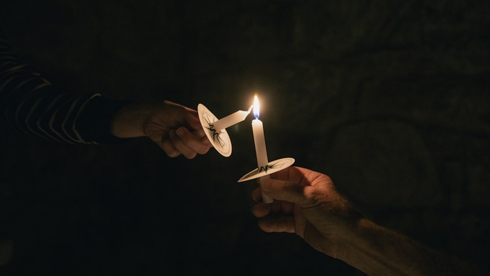 Dos personas sosteniendo una vela en sus manos