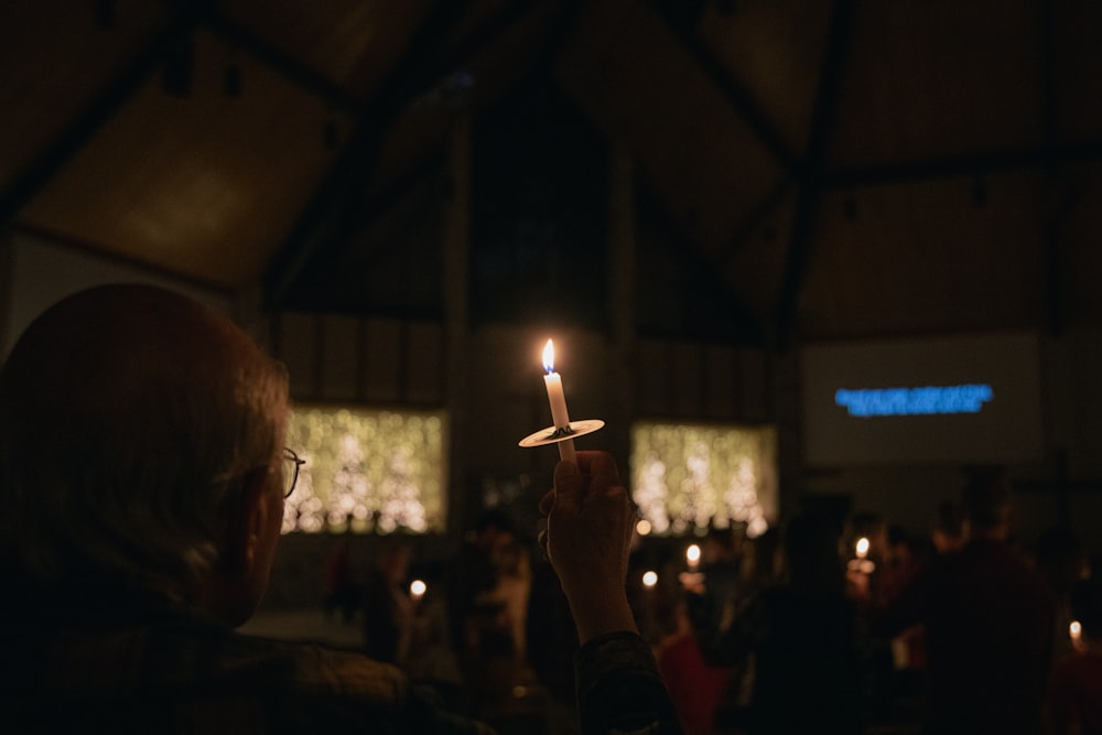 a man holding a lit candle in his hand