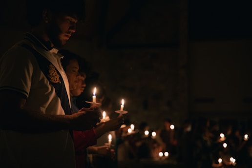 A peaceful family gathered around a glowing candle, sharing a quiet moment of prayer and devotion at home.