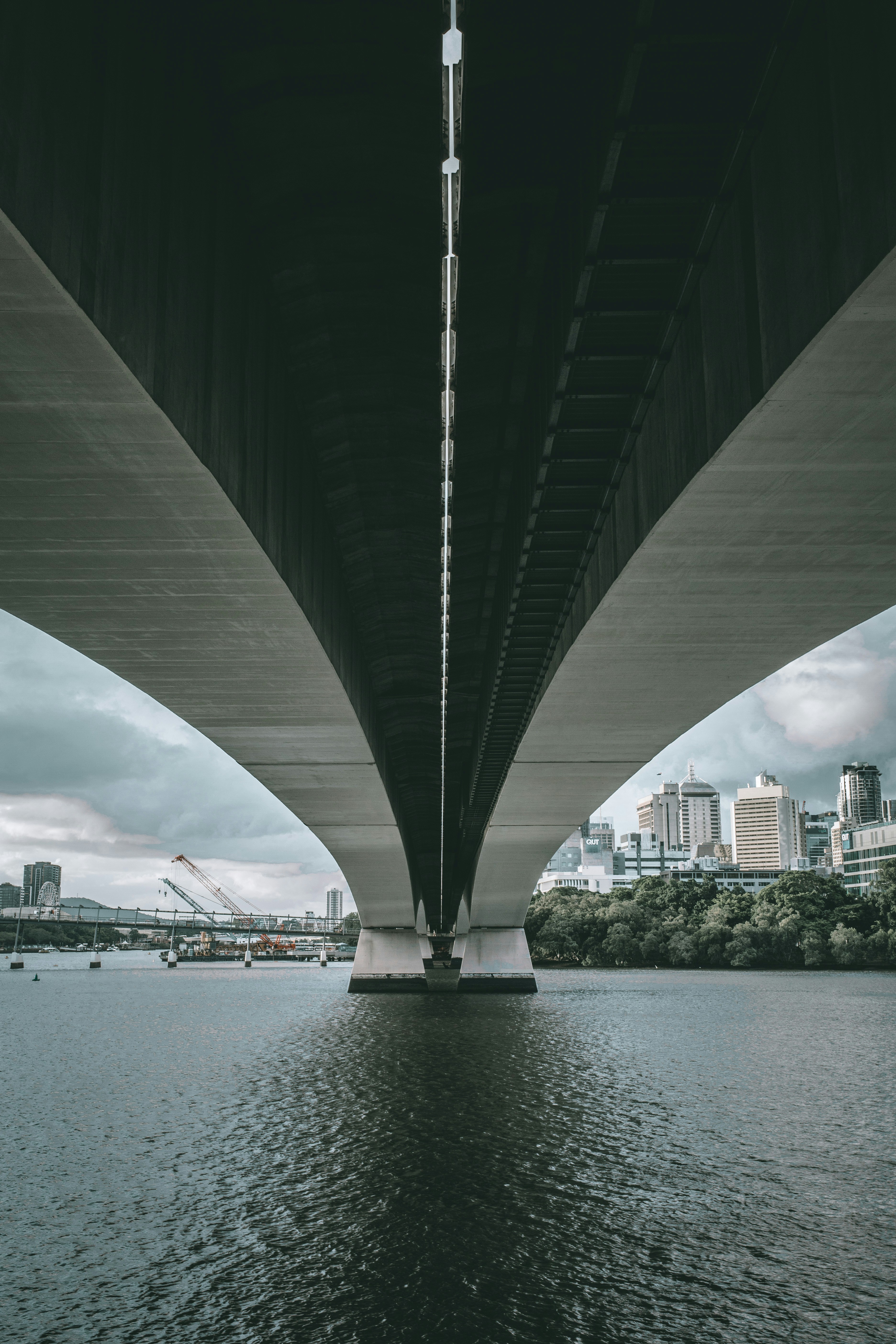 a bridge over a body of water with a city in the background