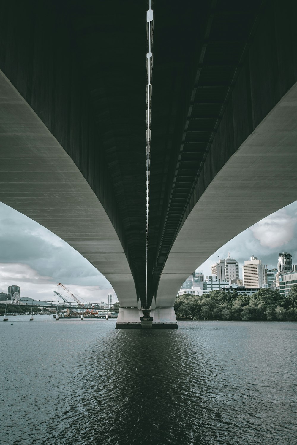 a bridge over a body of water with a city in the background