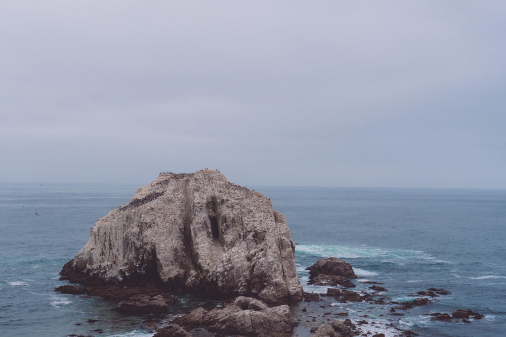 a large rock sticking out of the ocean