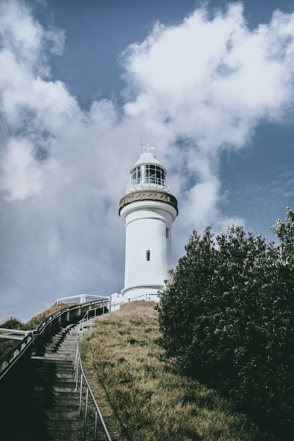 a lighthouse on a hill with stairs leading up to it