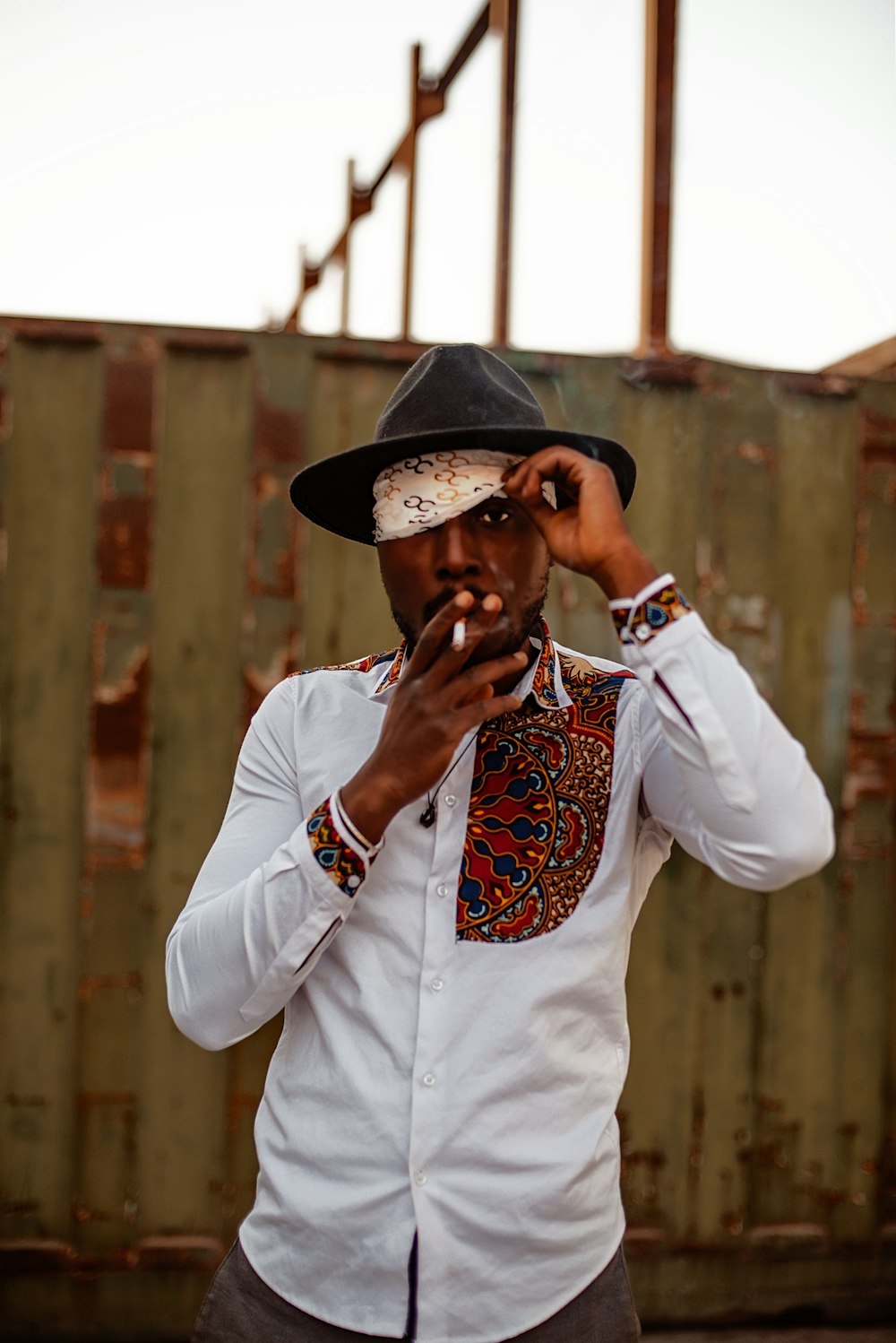 a man in a hat smoking a cigarette