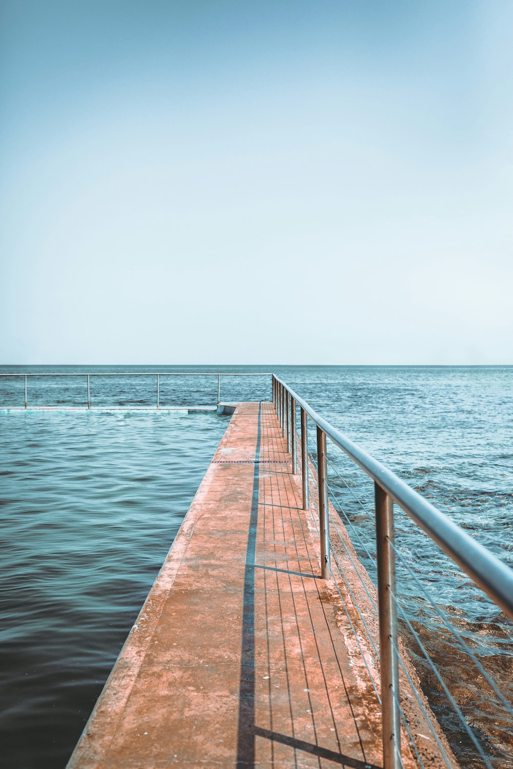 a long pier stretches out into the ocean