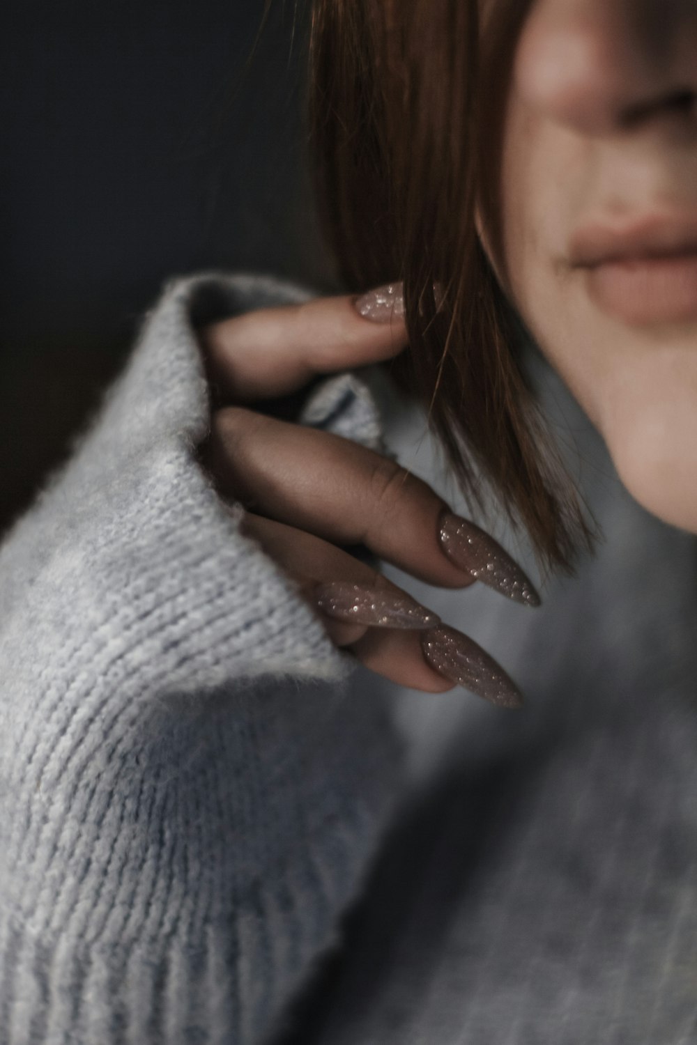 a close up of a woman's hand holding a sweater