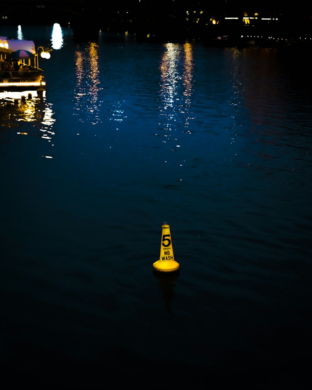a yellow cone floating on top of a body of water