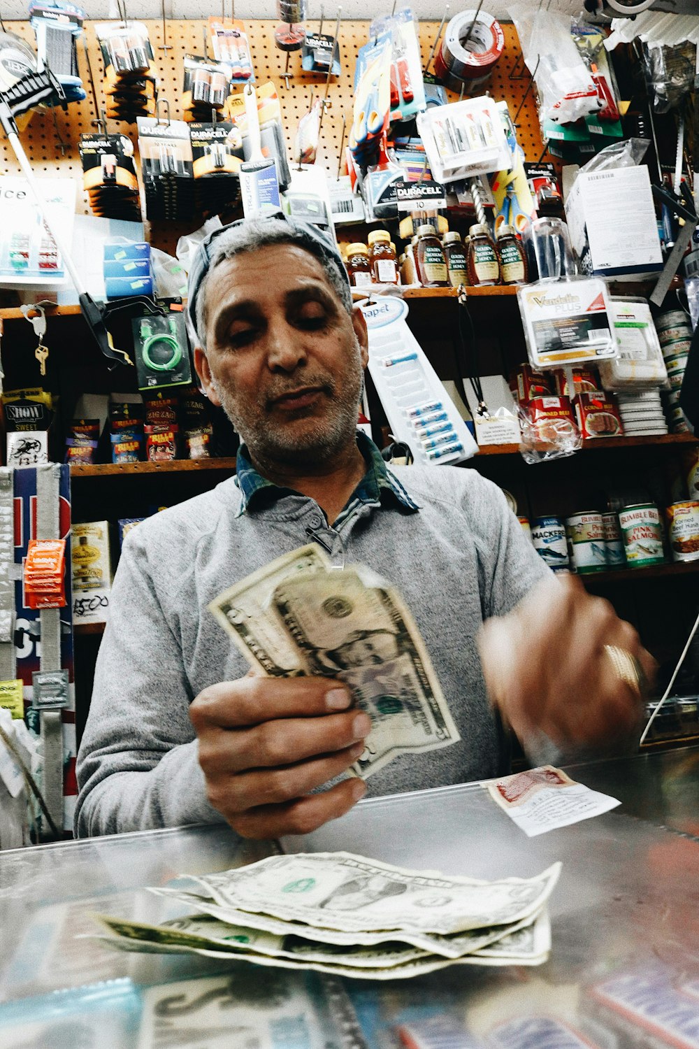 a man sitting at a counter holding a stack of money