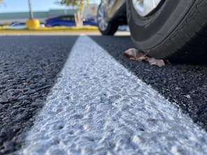 Close-up of a modern tow truck tire and equipment resting on an asphalt road background