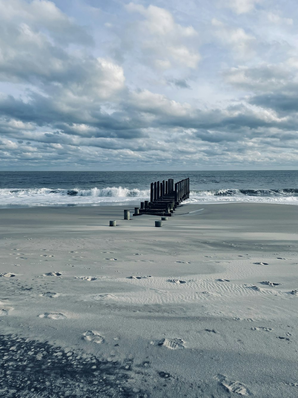 a beach with a wooden structure in the middle of it