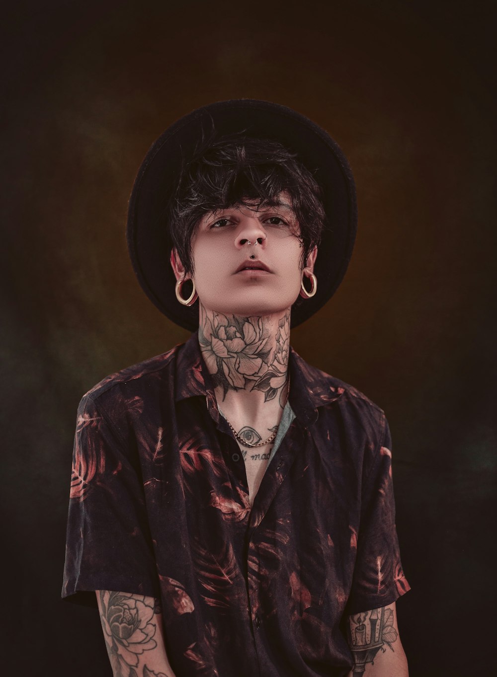 a man with tattoos and a hat on