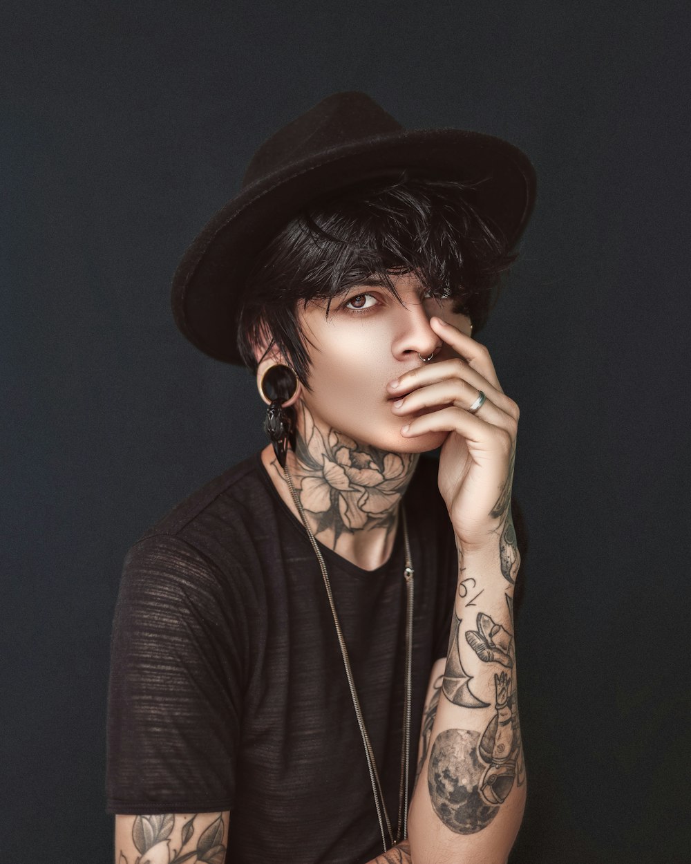 a man with tattoos and a black hat