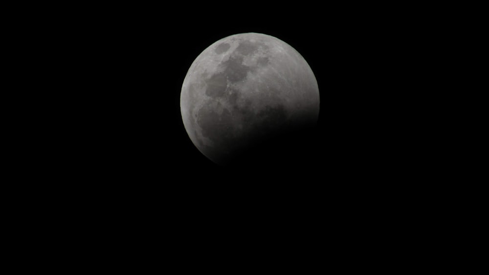 the moon is seen in the dark sky