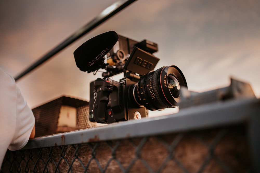 a camera sitting on top of a metal fence