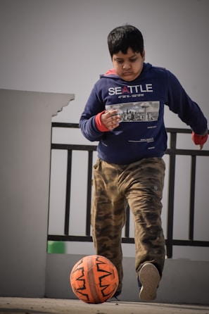 A boy playing soccer in comfortable solelegend activewear on a sunny day.